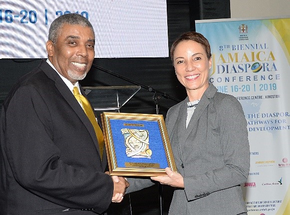 Leon Mitchell, Assistant General Manager, The Jamaica National Group receives a gift from Senator Kamina Johnson-Smith Minister of Foreign Affairs and Foreign Trade at the launch of the Diaspora Conference.